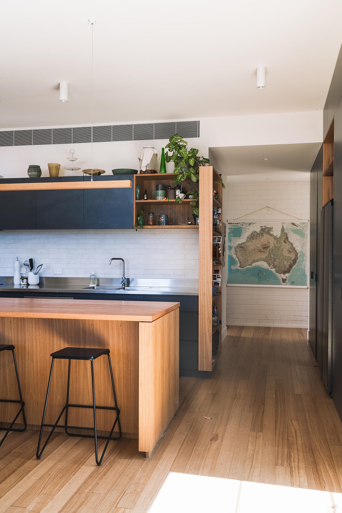 New modern timber and charcoal kitchen with plants and kitchen objects. Map of Australia in the background. Sustainable living Preston