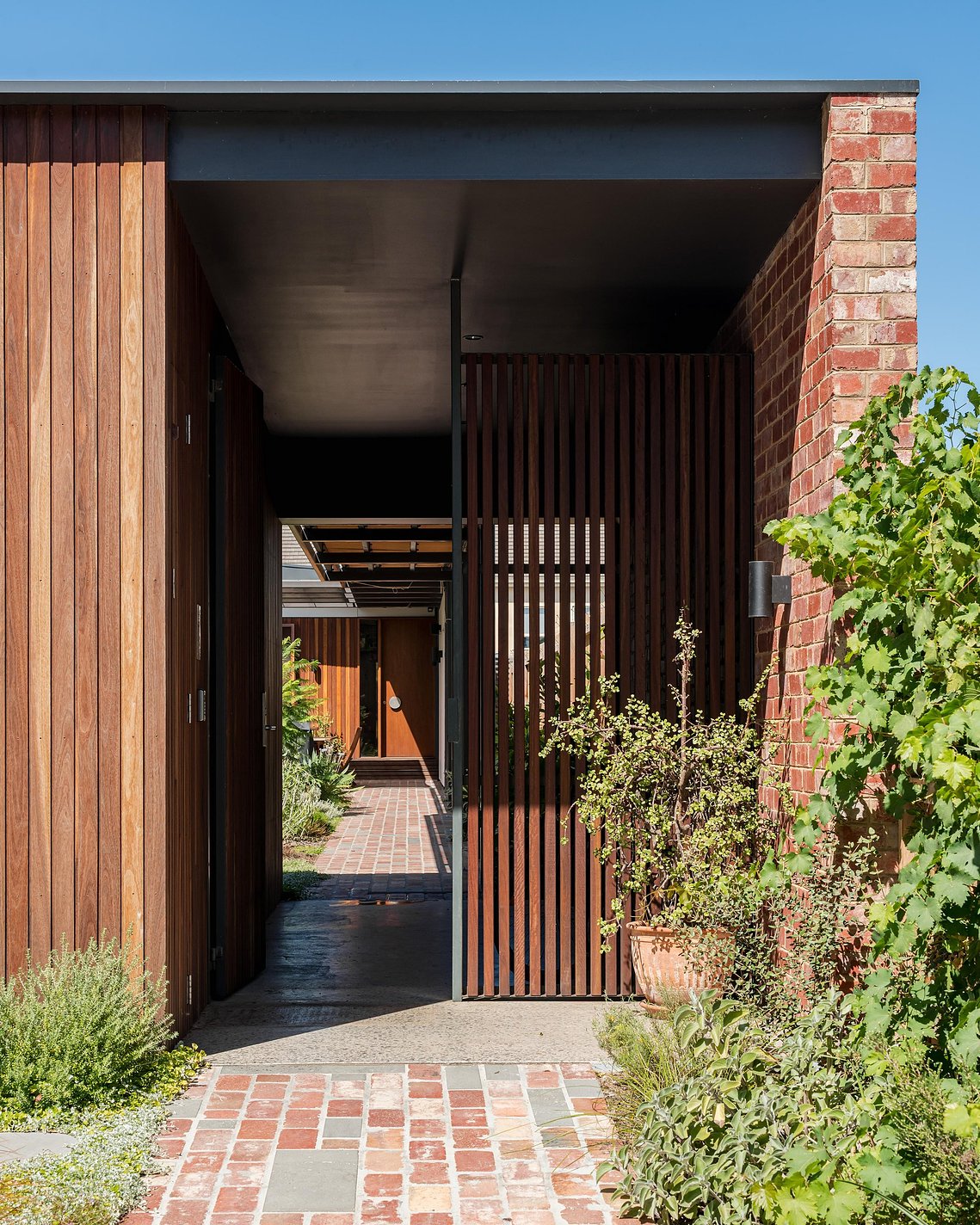 Street entry looking towards a house through a garden in the distance. Sustainable living in Brunswick