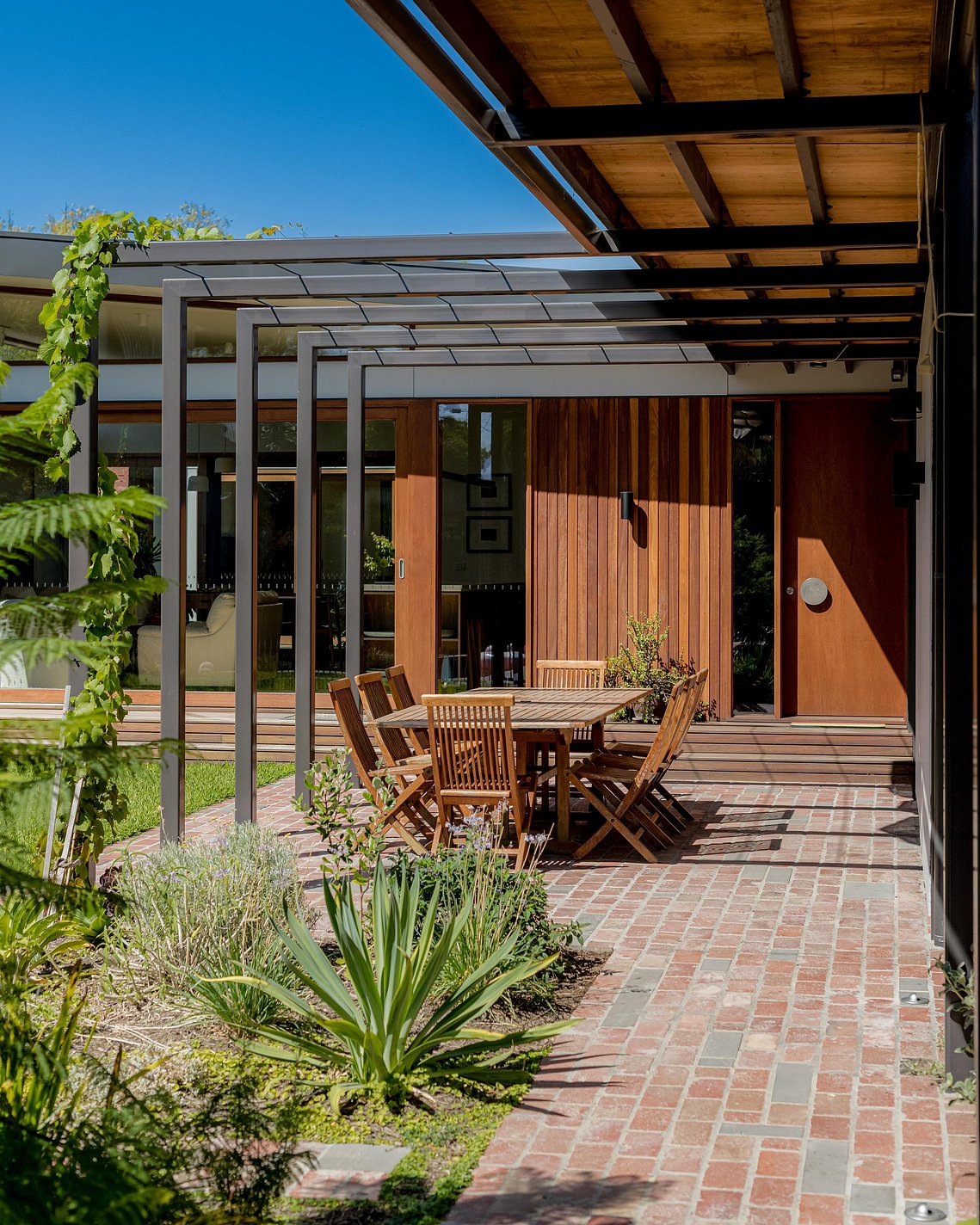 Entrance into a new house from a covered walkway area. The front door has a circular door handle. Sustainable living Brunswick