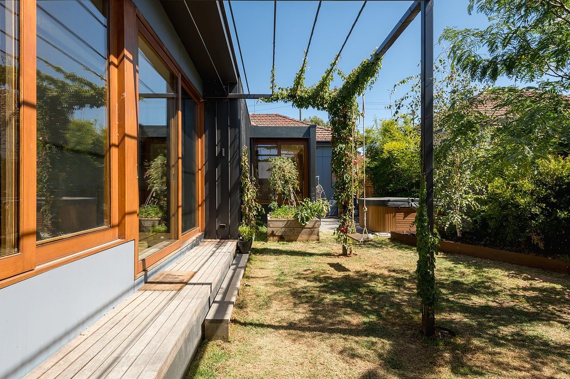 Sustainable alterations and additions in Preston. Photo showing north facing outdoor space with new living dining room large  timber sliding doors 