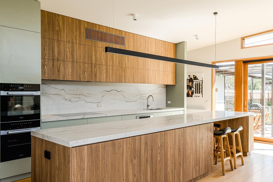 New kitchen with soft green coloured cabinets and feature timber veneer.  Sustainable living Brunswick