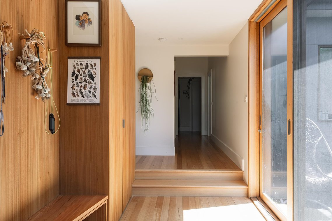 Interior link between existing house and new extended house. Warm timber floors and cabinets with large north facing timber sliding doors. Sustainable Living Preston