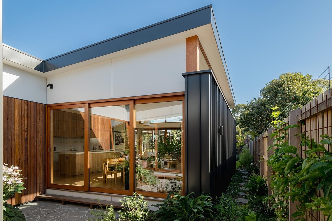 External façade of building facing new central courtyard. Plants surround the space. Sustainable living in Brunswick