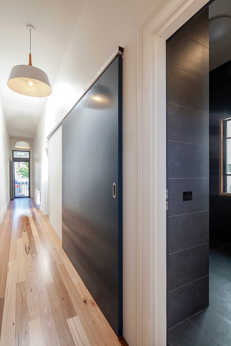 A laundry is "hidden" behind a large sliding door