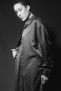 Black and white photo of a woman wearing a long silk blouse and is in motion. Ilford Film