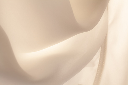 Soft fabric, white silk, high key, abstract curtain. Curved lines formed by a silk shirt against the light