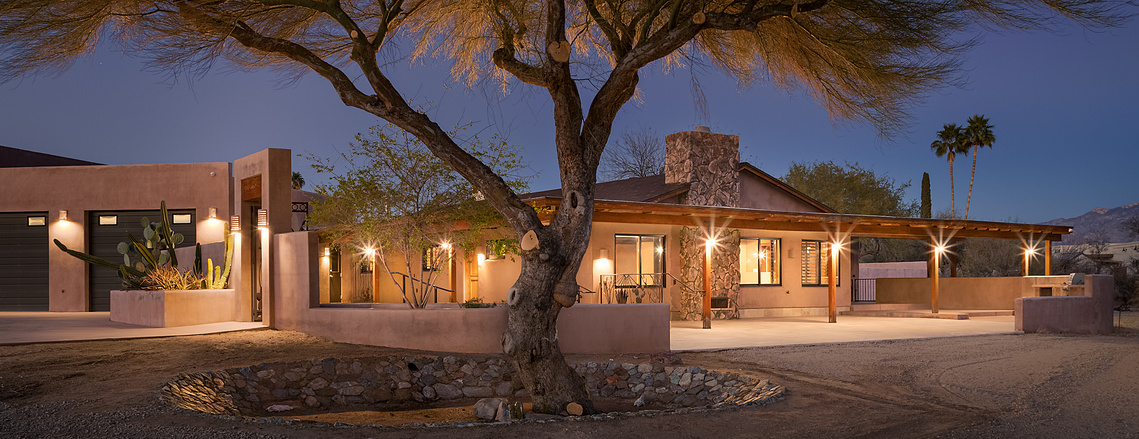 Beautiful twilight lighting on this home in Tucson AZ. with large tree in a well.  