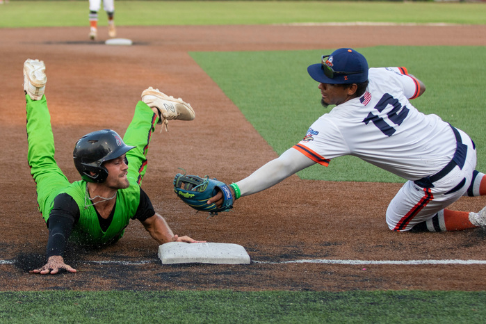 Tri-City Chili Peppers second baseman Dalton Hurst slides into third base avoiding the tag from Peninsula Pilots third baseman Christopher Martinez early in the game at War Memorial Stadium on July 27, 2023.