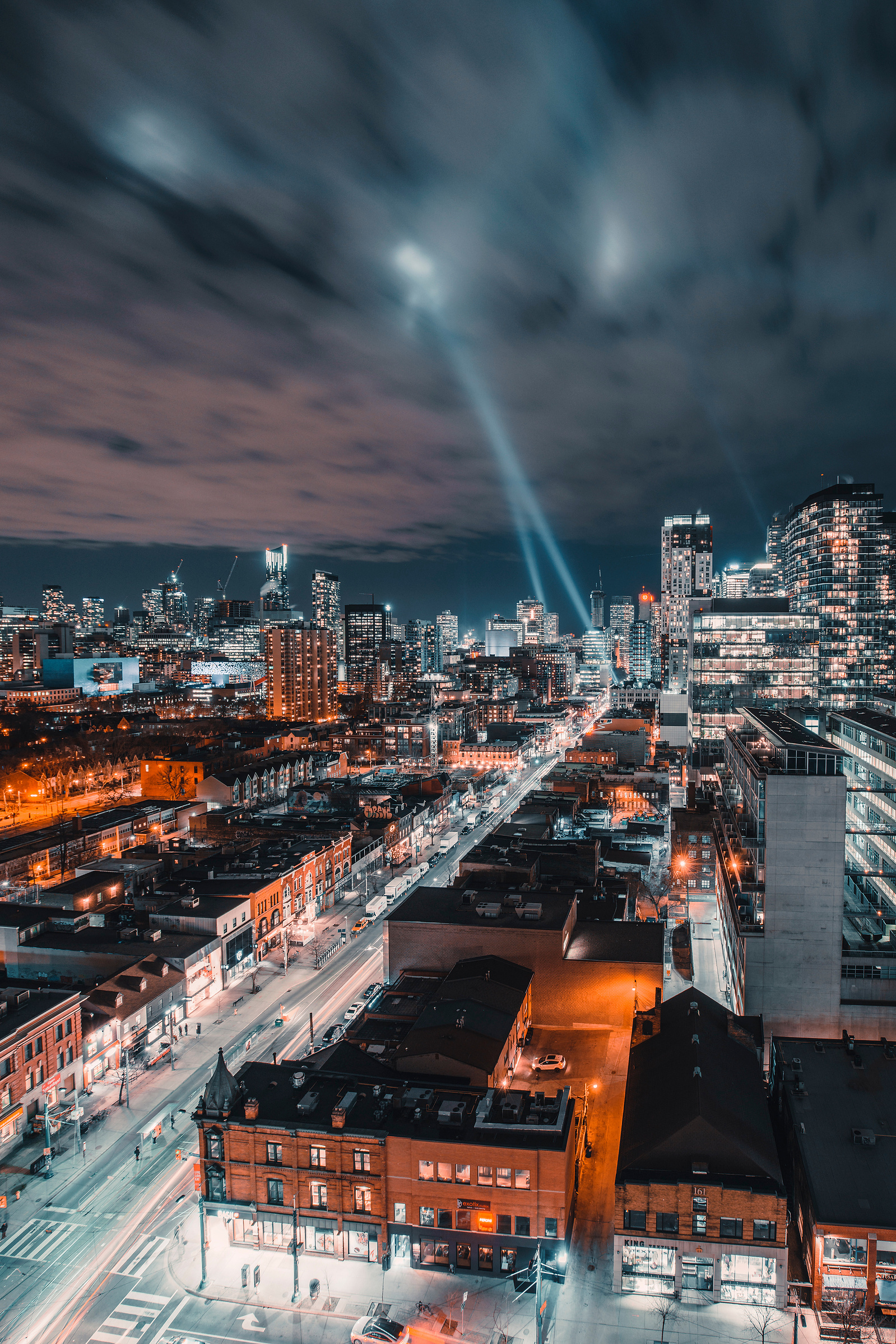 Search lights in Queen West at night in Toronto from a rooftop
