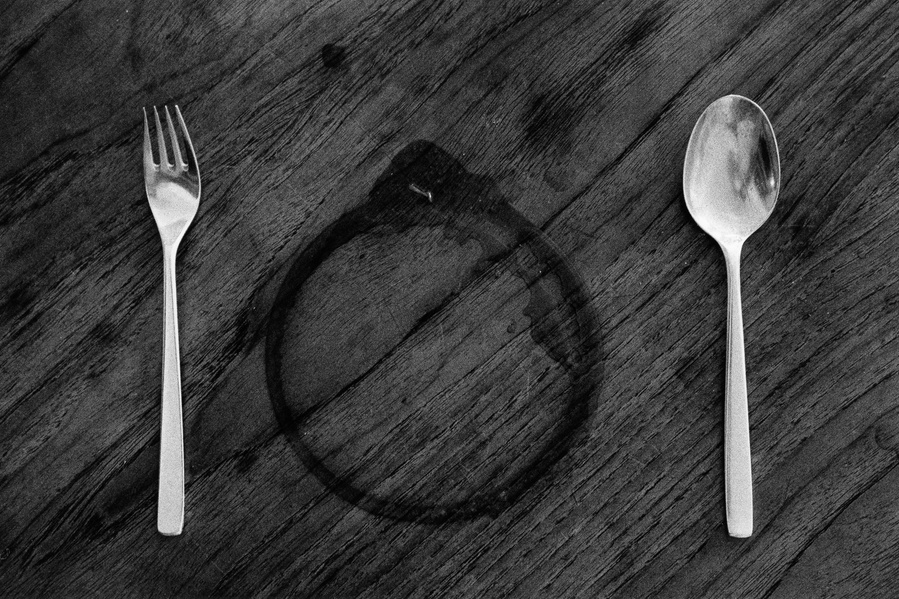 Black and white photograph of a plate stain and silver cutlery 