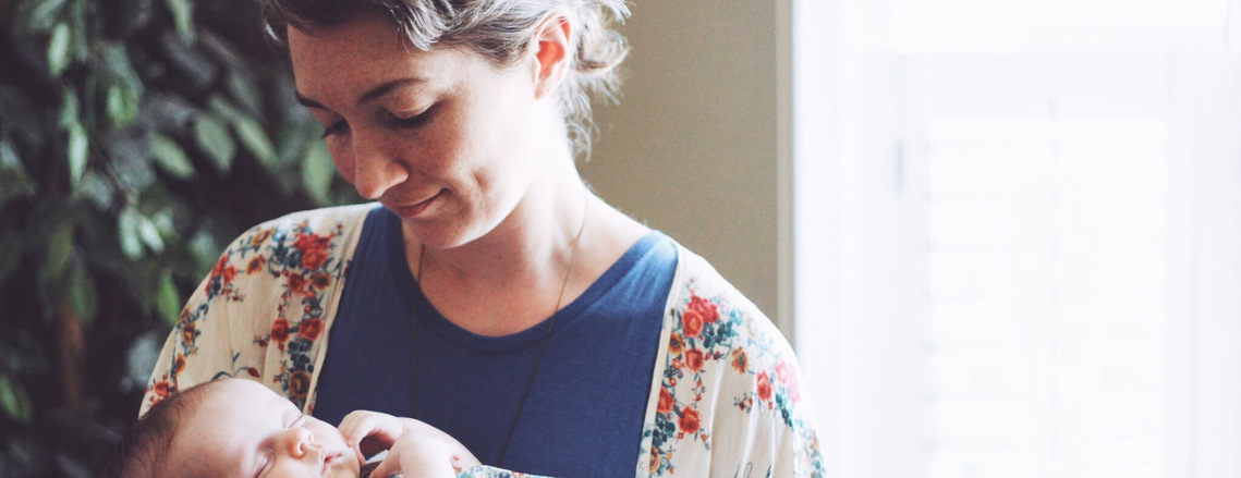 An image of Molly holding a sleeping baby.