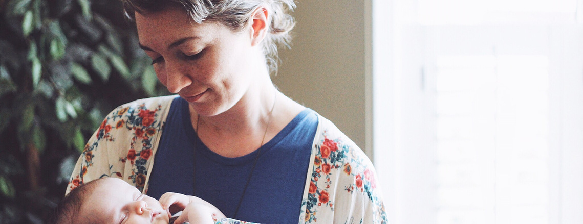 An image of Molly holding a sleeping baby.
