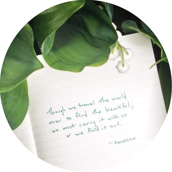 A notebook tucked among lily of the valley with a quote from Emerson: 