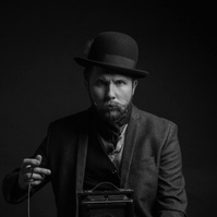 Dramatic portrait of photographer holding vintage 4x5 film camera and taking a picture photographed by commercial and editorial photographer Jason Barnes in San Antonio, TX