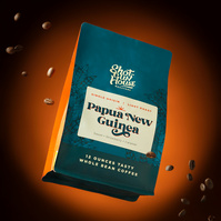 Image of Shotgun House Roasters bag of coffee on orange background suspended in air with flying coffee beans around it photographed in San Antonio, TX by commercial advertising photographer Jason Barnes
