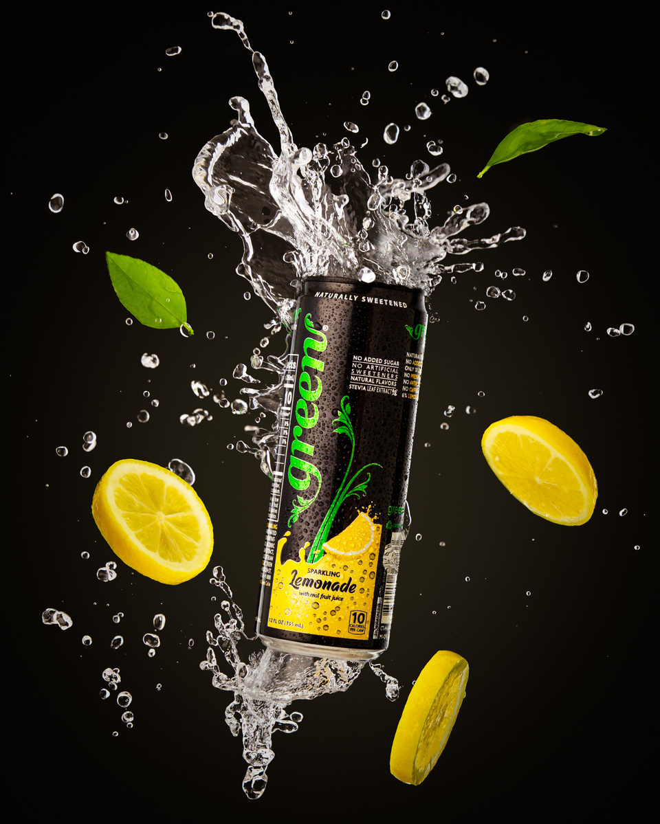 Image of Green Soda Sparkling Lemonade with water and fruit splashing around it suspended in air photographed by commercial photographer Jason Barnes