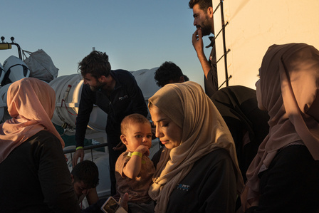  family group of Syrian women and a newborn, rescued the night before from a distressed boat after nearly 24 hours of malfunction off the coast of Libya, aboard Emergency's LifeSupport ship, await permission to dock at the port of Naples.