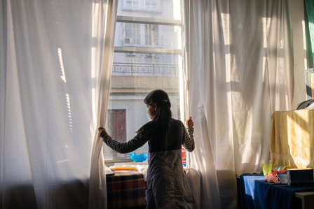 An Afghan girl peers out from the window of an occupied building in the Exarchia neighborhood, where she has been living with her mother and father for several months. In the Exarchia district of Athens, a network of anarchists and anti-fascist movements 