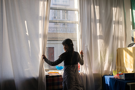 An Afghan girl peers out from the window of an occupied building in the Exarchia neighborhood, where she has been living with her mother and father for several months. In the Exarchia district of Athens, a network of anarchists and anti-fascist movements 