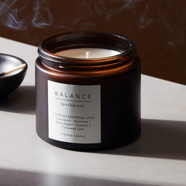 Product photography by sally williams of a candle on a grey concrete background with smoke and hard shadows