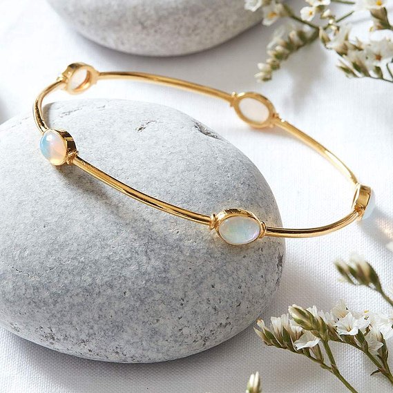 NOTHS jewellery photography UK, a boho gemstone bracelet on a natural pebble background with dried flowers