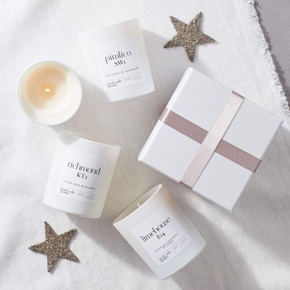 Christmas candle photography, three candles with a white gift box and silver stars on a white linen background
