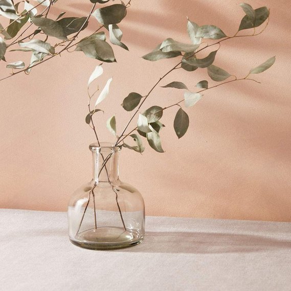 Homeware photography of a glass vase with dired flowers and dappled light.