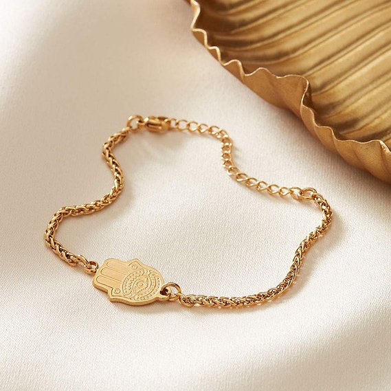 NOTHS jewellery photographer uk, minimal gold bracelet on a fabric background with gold dish