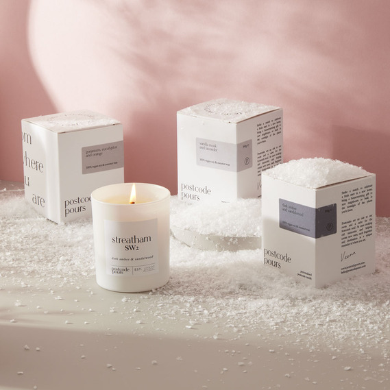 Christmas product photography, personalised candles on a pink background with artificial snow 