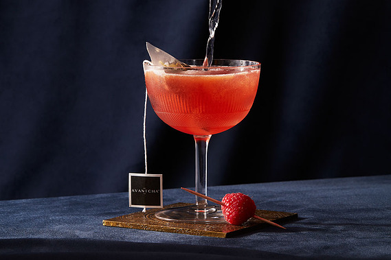 Cocktail product photography.  Earl Grey tea Cocktail served in coup glass on a dark navy background