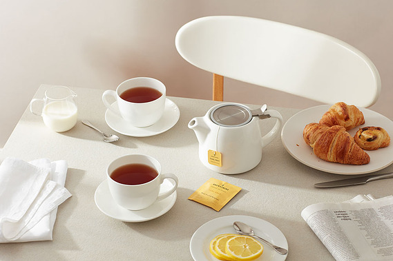 Tea product photography.  Earl Grey shown with cups and teaspoons in a breakfast tabletop scene with daylight shadows
