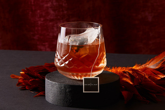 Cocktail product photography.  Chocolate Chilli tea served in a crystal glass on a dark moody background 