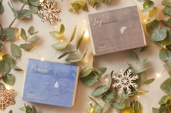 Christmas product photography, skincare gift sets with fairy lights, snowflake decorations and fresh foliage