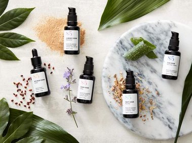 Beauty product photography of skincare products with natural ingredients and fresh foliage