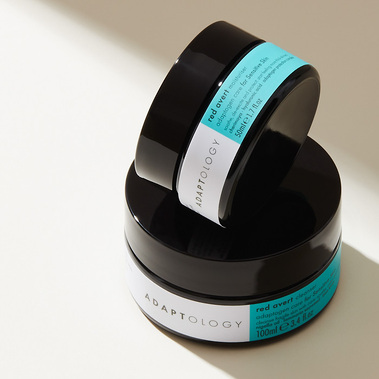 Skincare product photography, two moisturiser jars stacked in a shaft of sunlight minimalist style