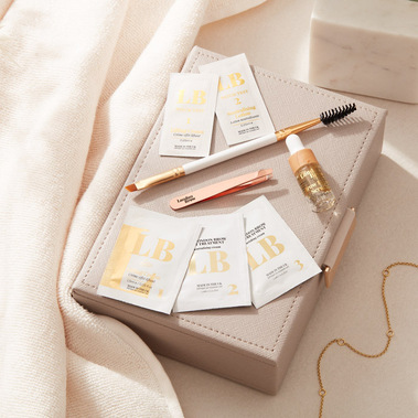 Beauty product photography, brow lamination products on a dressing table with a jewellery box and towel