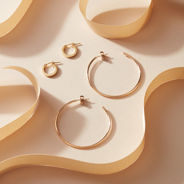 Minimalist jewellery styling, earrings with curved gold ribbons