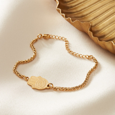 Jewellery photography of gold bracelet on a  beige satin background