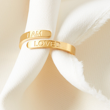 Gold ring on a soft neutral fabric background 