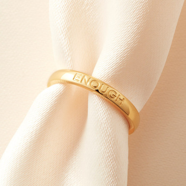 Modern jewellery photography of a gold ring on a neutral fabric