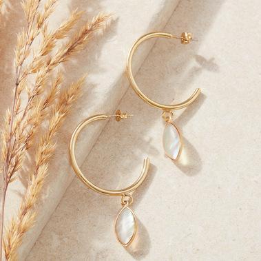 Lifestyle jewellery photography styled with props and daylight shadows, natural stone and dried foliage