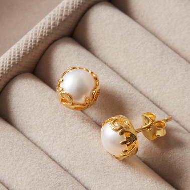 Gold and pearl stud earrings in a taupe coloured jewellery box