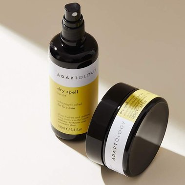 Minimal beauty product photography of two skin care bottles in a shaft of light