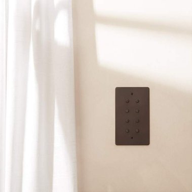 Homeware product photography of Focus SB designer light switches on a neutral colour wall with white linen  curtains