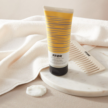 Haircare product photography of a hair mask with a towel and comb