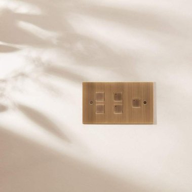 Homeware product photography of Focus SB designer light switches in a dappled leaf shadow on a neutral painted wall