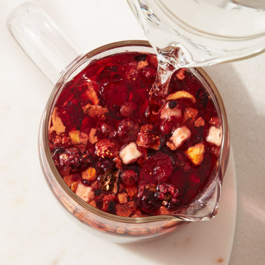 Tea product photography.  Water being poured into a teapot with fruit tea