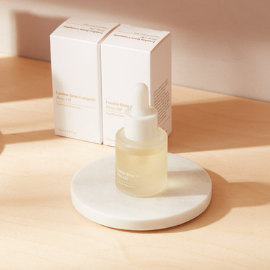 Lifestyle beauty product photography of brow oil on a light wooden background with shadows