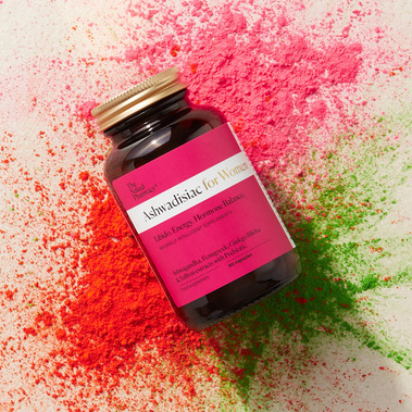 Ashwadisiac supplements for Women, a jar flatlay with explosions of coloured powder behind it