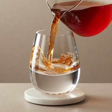 Tea product photography. Cold brew tea being poured into a glass on a neutral background